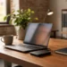 Wooden office desk with a laptop connected to a small external backup drive, a notebook, and a coffee mug.